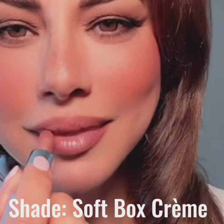 Woman applying Satin Shimmer Crème Lipstick in Soft Box, showing light-catching nude pink color and smooth formula