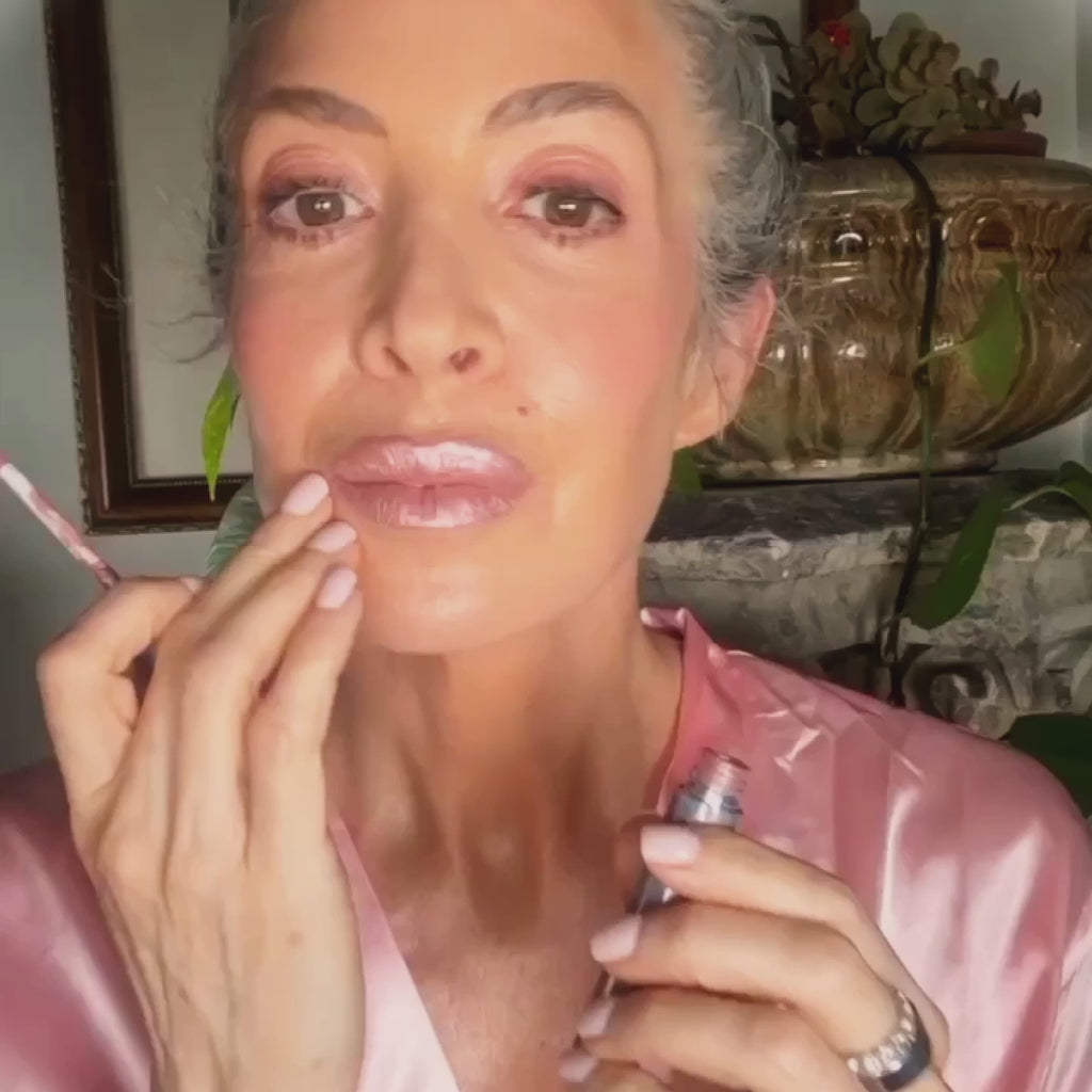 Mature model applying Runway Rogue Pearl Glam liquid lipstick in the shade Soft Box